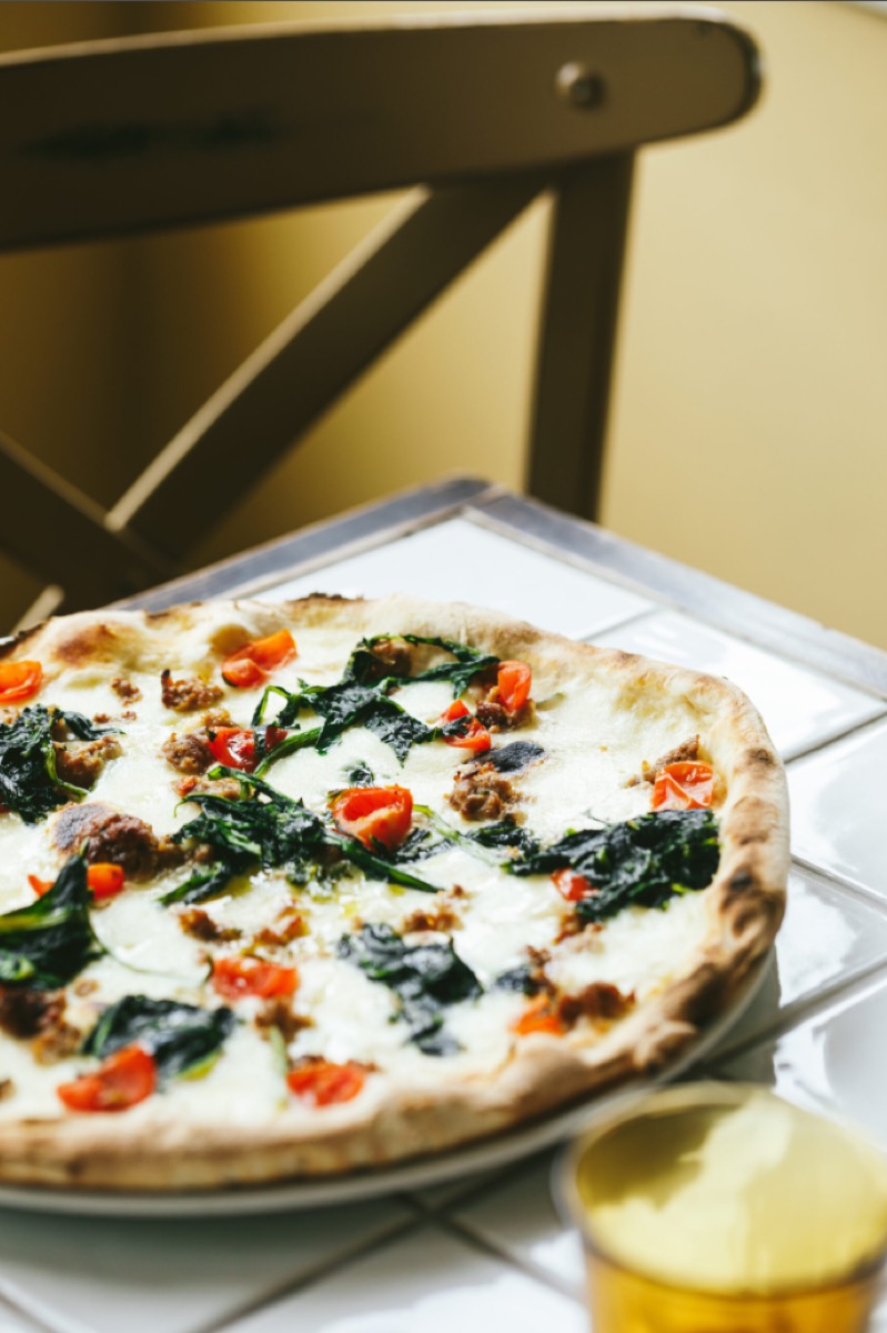 White pizza with spinach and Italian sausage