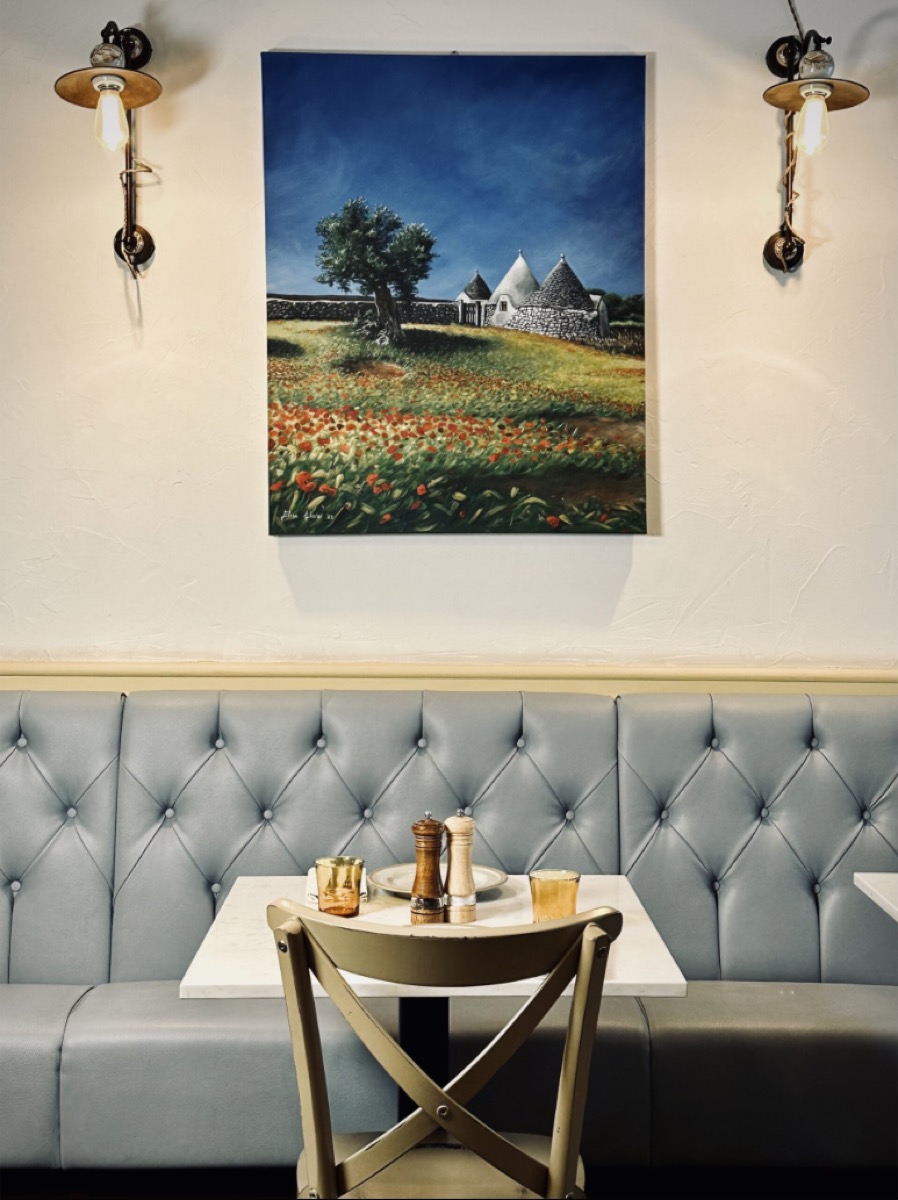 Blue tufted banquette with Puglia trulli painting